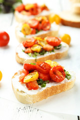 Fototapeta na wymiar Tasty fresh bruschetta with tomatoes on white wooden background