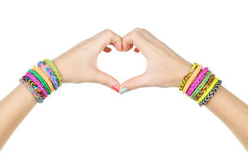 Female hands in shape of heart with colorful rubber band bracele