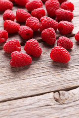 Red raspberries on grey wooden background