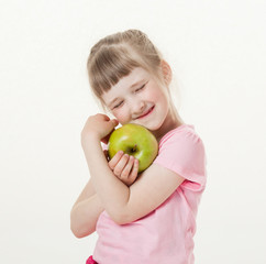 Fototapeta na wymiar Happy little girl holding a green apple
