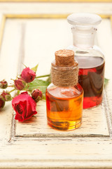 Obraz na płótnie Canvas Rose essential oil and rose flowers. Spa, body care and aromatherapy.