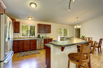 Large kitchen with hardwood floor, and bar.