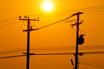 Silhouette of electric pole power lines and wires in sunset