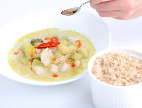 Chicken green curry with rice on white