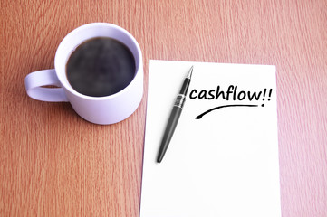 Coffee, pen and notes write cashflow