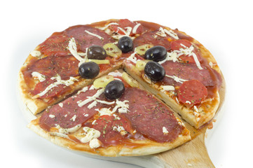 Sliced round pizza and raw vegetables served on a wooden plate o