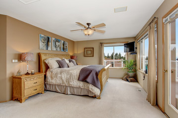 Large master bedroom with connected bathroom and cream bedding.