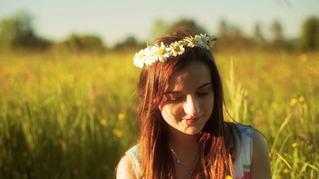 Pretty girl smeling bunch of flowers on the meadow
