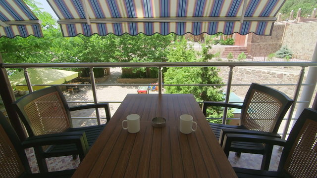 Terrace under folding awning in a sunny summer day