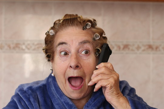Old lady with curlers surprised on the phone