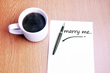 Coffee, pen and notes write marry me