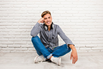 man with headphones sitting on the floor