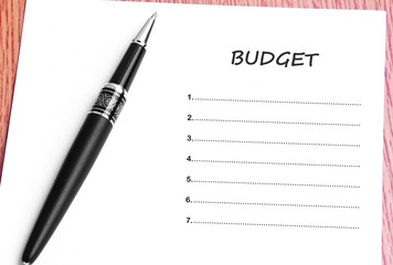 Pen  and notes paper with budget list