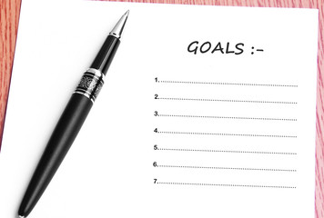 Pen  and notes paper with goals list