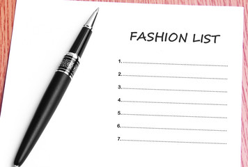 Pen  and notes paper with fashion list