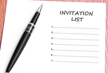 Pen  and notes paper with invitation list