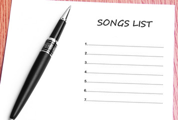 Pen  and notes paper with songs list