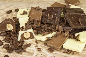 Pieces of chocolate on a wooden board. Sweet chocolate pleasure on the table.

