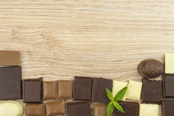 Pieces of chocolate on a wooden board. Sweet chocolate pleasure on the table.
