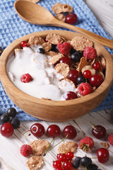 flakes with milk and berries close up in a wooden bowl. Vertical
