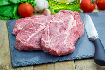 Raw beef steak on a black slate tray