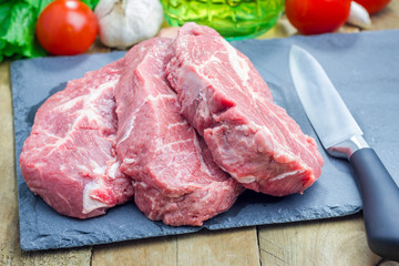 Raw beef steak on a black slate tray