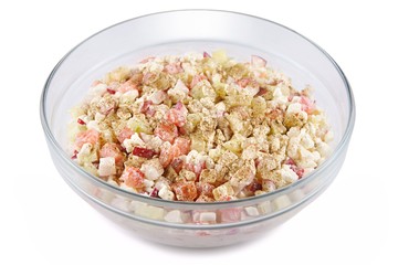 Cottage cheese, tomatoes, cucumbers and radishes, cut into cubes and mixed with spices in a glass bowl, on a white background
