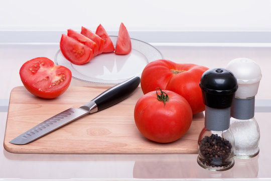 Tomatoes and knife on a chopping board