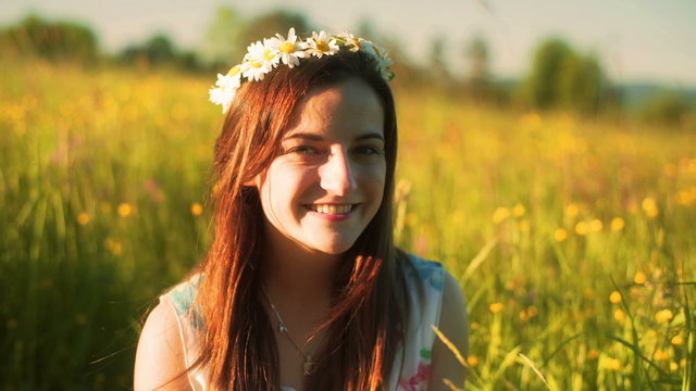 Pretty girl holding flowers and smiling to the camera, steadycam shot

