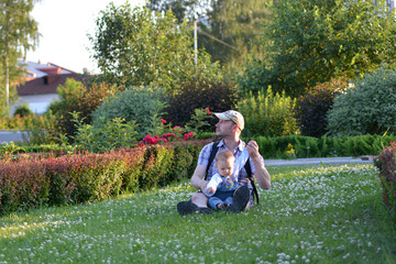 Naklejka na ściany i meble Father and son playing on summer green grass 