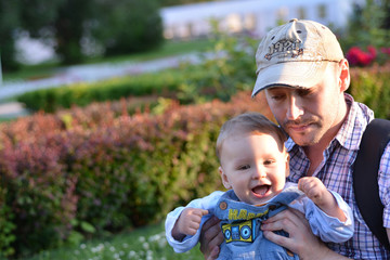  Father and son playing on summer green grass 