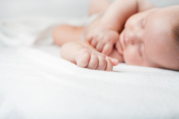 Newborn baby sweet sleeping on a white bed