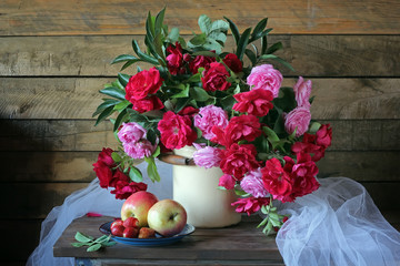 Букет из красных и розовых роз, клубника и яблоки на деревянном столе. Натюрморт с розами и клубникой.