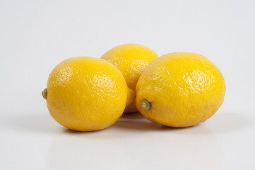 three yellow lemon on white background