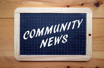 The phrase Community News in white text on a blackboard
