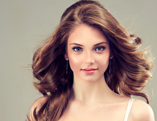 Fototapeta premium Beautiful young girl with long hairstyle curly hair 