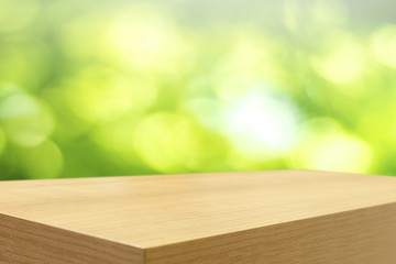 Empty wooden table and green natural spring blur bokeh backgroun