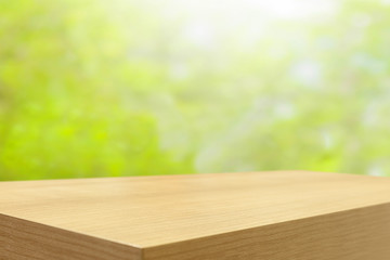 Empty wooden table and green natural spring blur bokeh backgroun