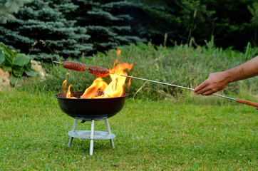 Grilling sausages over a fire