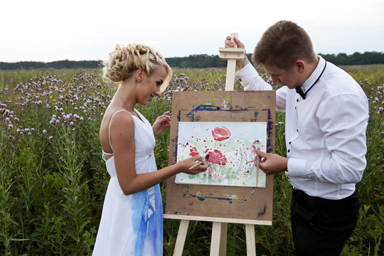 the bride and groom paint on an easel emotion