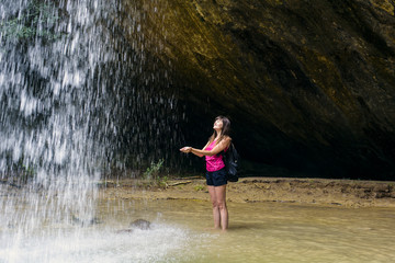 young caucasian female hiker near the waterfall