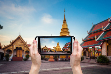 Hand taking photo at Wat phra that hariphunchai was a measure of