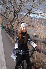 Young beautiful woman riding a bicycle at kawaguchiko Lake,Japan