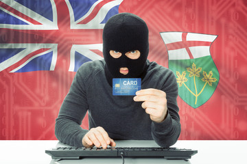 Hacker holding credit card and Canadian province flag on background - Ontario