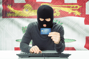 Hacker holding credit card and Canadian province flag on background - Prince Edward Island