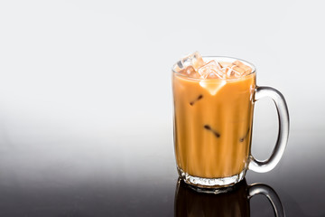 Refreshing ice cold coffee with milk in transparent glass