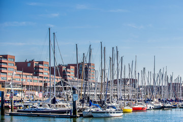 Small harbour with sailing boats on a blue sky