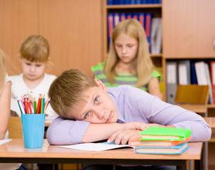 tired schoolboy at a lesson at school