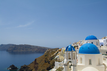 Fototapeta na wymiar Santorini famous Orthodox church with blue domes in village Oia