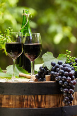red wine bottle and wine glass on wodden barrel